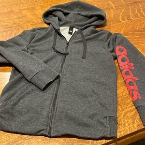 Adidas medium gray zip up hoodie with red arm brand letters. Front pockets.